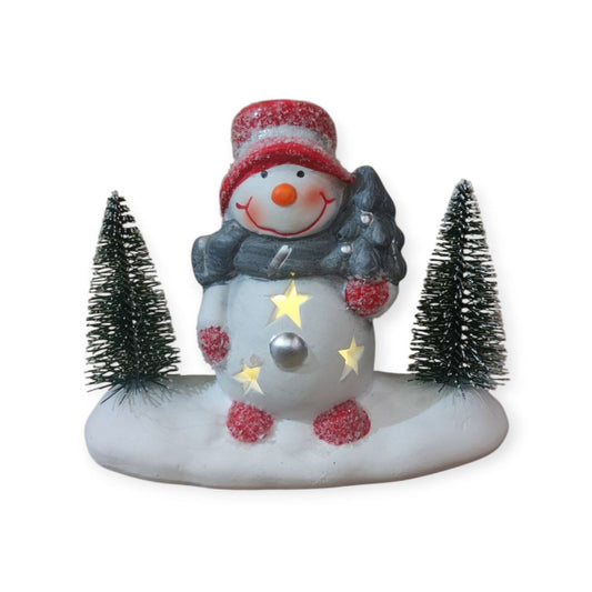 Snowman by the glowing tree